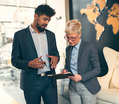 Hombre y mujer revisando las estrategias internacionales para una compañía